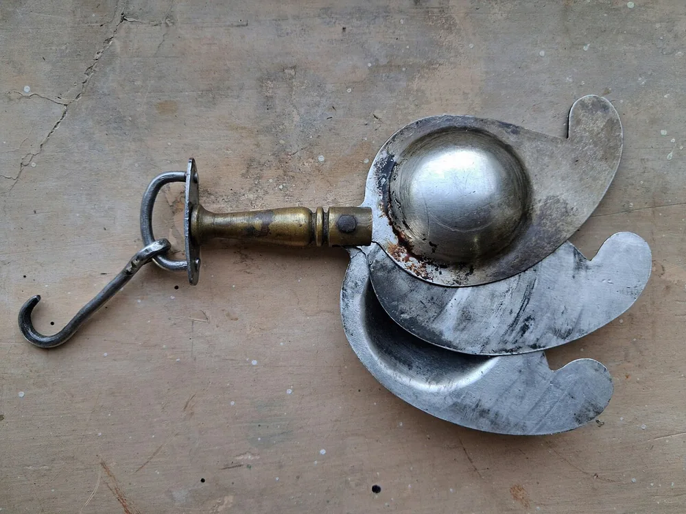 Steel kohl container with a brass handle in a paisley shape, a family heirloom from Bihar, India