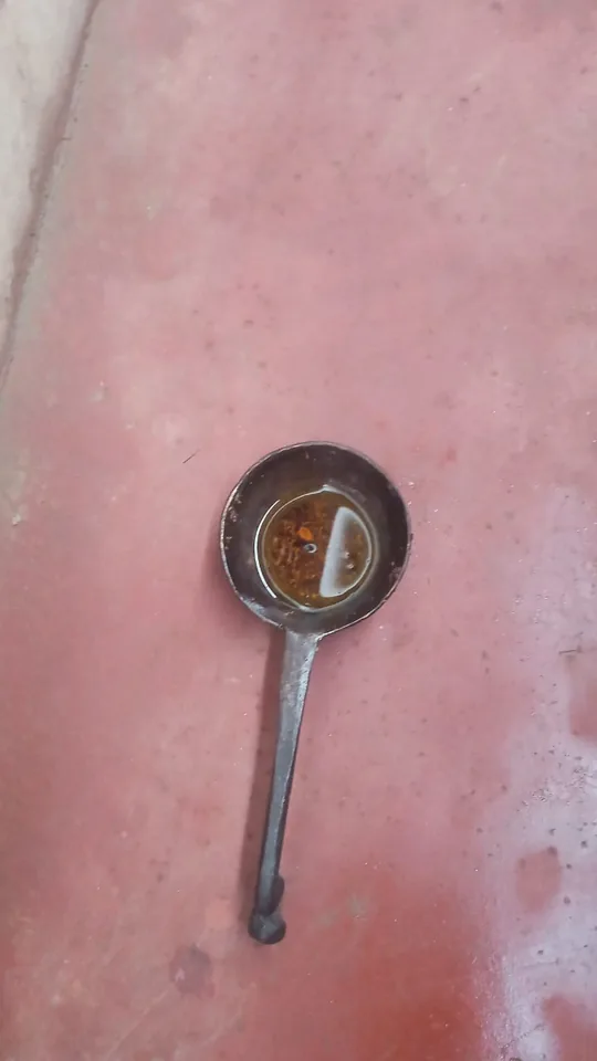 A maliya, an open iron container with a long handle used for heating oil for massage