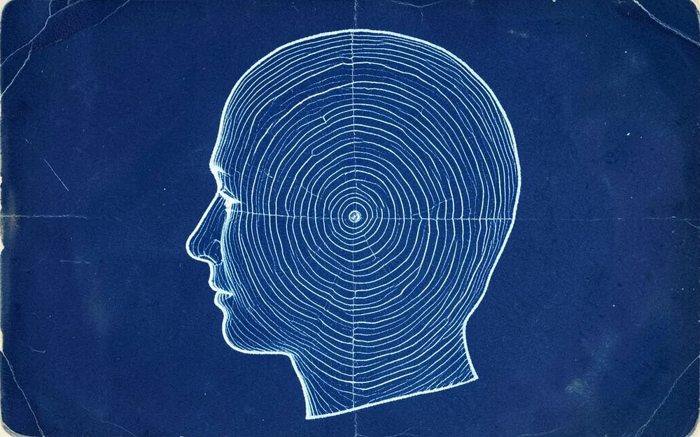 Cyanotype-style print of a human head silhouette filled with tree growth rings
